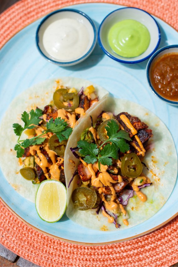 Baja-style blackened salmon flour tacos topped with guacamole